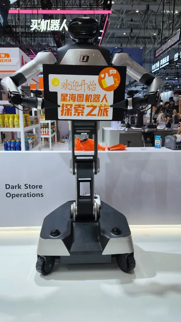 Humanoid robot holding a sign at a dark-store operations exhibit