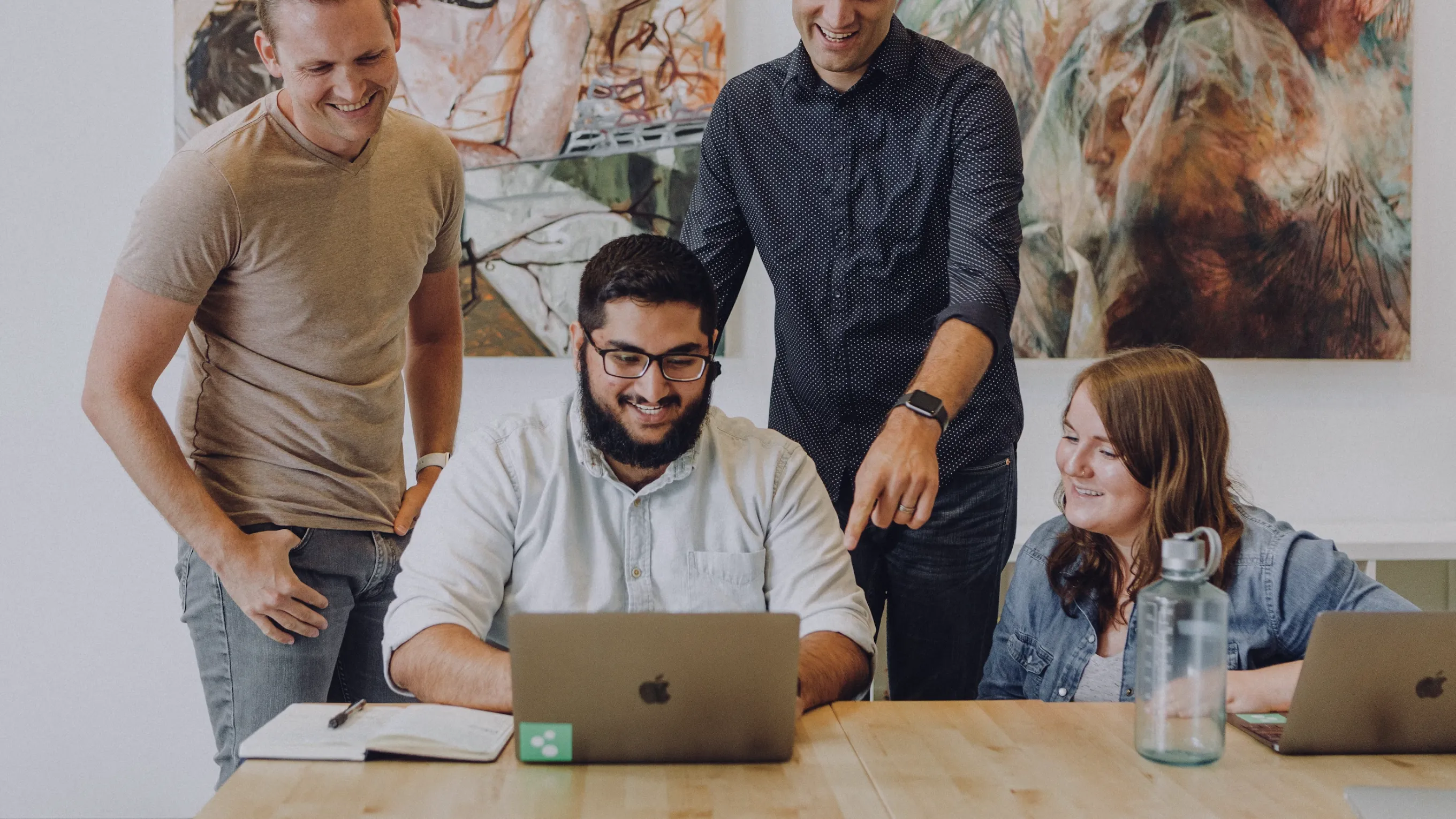 Team collaborating around a laptop