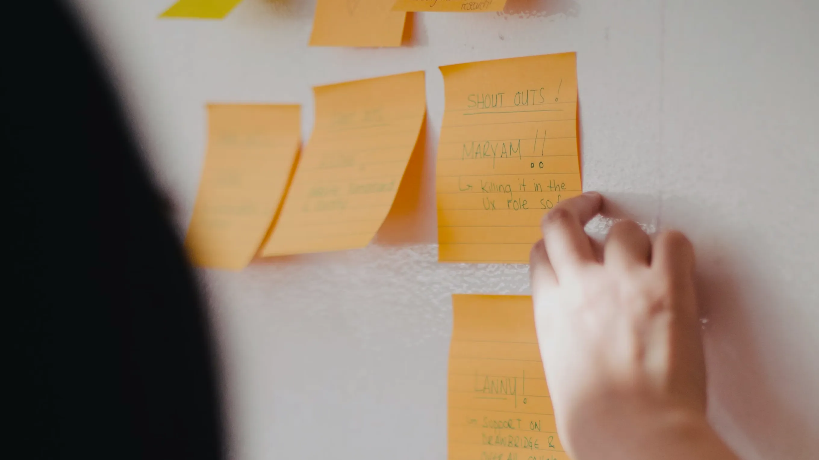 Person arranging sticky notes on a wall